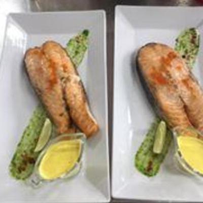 Salmon steak, marinated in herbs, served with sauce 